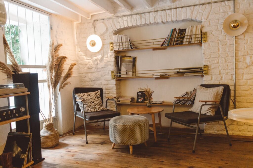 living room with white stone walls, bookshelf, and striped furniture