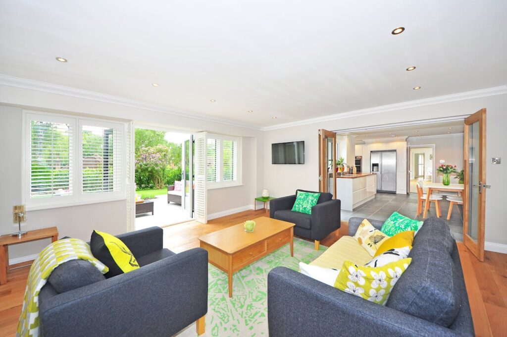 living room with green rug and open doors to kitchen and outside